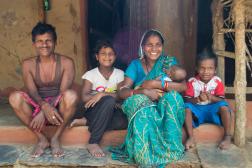 Family from Uttampur, Odisha, India sits on the step of their house.